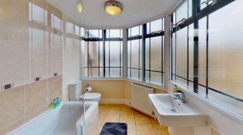 a bathroom with a sink and a tub and a toilet at Niche Water Tower Apartments in Braintree