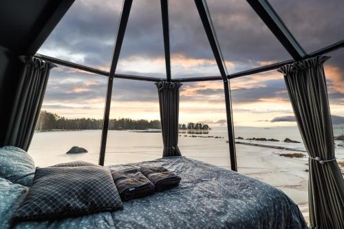 Habitación con cama y ventana grande. en Arctic Lake Experience Oulujärvi Igloos en Kajaani