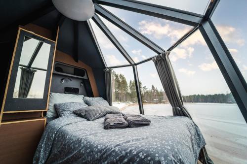 a bedroom with a bed in a room with windows at Arctic Lake Experience Oulujärvi Igloos in Kajaani