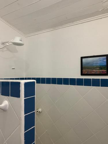 bagno con TV a parete e servizi igienici di Casa Vila Tortuga a Arraial d'Ajuda