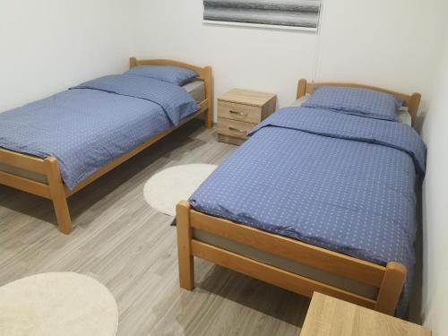 2 camas individuales en una habitación con 2 mesas en LUX Apartman Tara Pale Jahorina, en Pale
