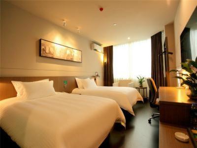 a hotel room with two beds and a window at Jinjiang Inn Select Wuxi Nanchang Street Huaqing Bridge Metro Station in Wuxi
