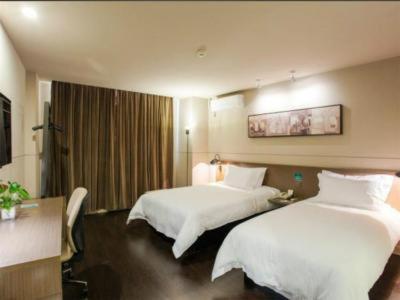 a hotel room with two beds with white sheets at Jinjiang Inn Select Wuxi Nanchang Street Huaqing Bridge Metro Station in Wuxi