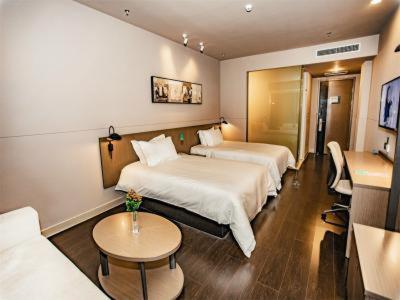 a hotel room with two beds and a table at Jinjiang Inn Select Linyi City Government Tianjin Road Branch in Linyi