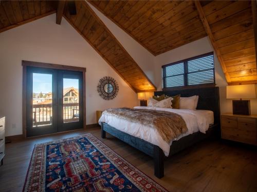 a bedroom with a large bed and a large window at Beautiful Views! Jacuzzi, Indoor/ Outdoor Fireplace, Steps to Lake Estes in Estes Park