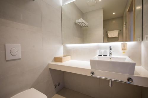 a white bathroom with a sink and a mirror at Hotel Osmine in Slano