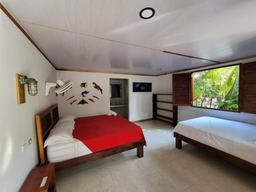 a bedroom with two beds and a window at Isla Grande Eco-Hostal in Isla Grande