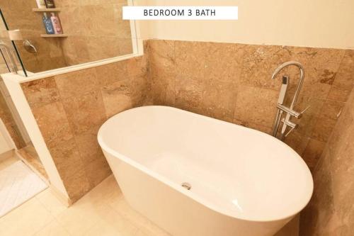 a bathroom with a bath tub and a sink at Vacation Pool House in the Serene Wilderness - Robert E Lee in Conroe