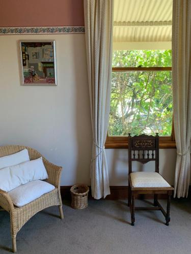 sala de estar con silla y ventana en Villa in the Vines, en Martinborough