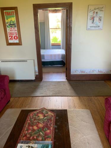 a living room with a room with a bed and a rug at Villa in the Vines in Martinborough 