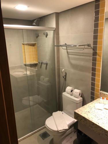 a bathroom with a toilet and a glass shower at Apto Master em Olímpia Park Resort in Olímpia