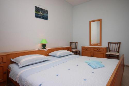 1 dormitorio con 1 cama, 2 sillas y espejo en Rooms Mare - economy rooms, en Sućuraj