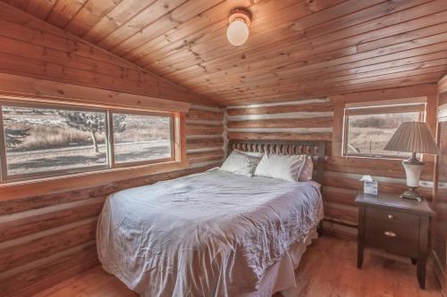 a bedroom with a bed in a wooden cabin at Erik's Ranch in Livingston
