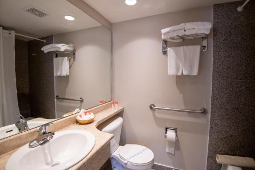 a bathroom with a sink and a toilet and a mirror at Canadas Best Value Inn-Prince George in Prince George
