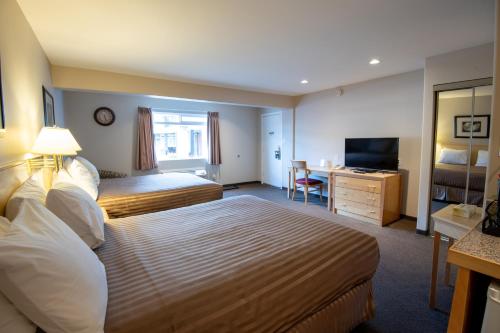a hotel room with a bed and a desk at Canadas Best Value Inn-Prince George in Prince George