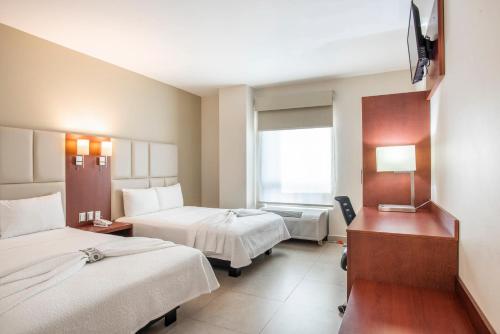 a hotel room with two beds and a window at Hotel Ave Inn in Mazatl&aacute;n