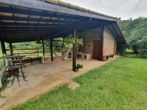 a pavilion with a picnic table and a picnic table at Espaço Casa na Rocha in São José dos Campos