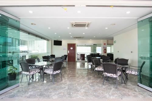 a conference room with tables and chairs and a television at Hotel Ave Inn in Mazatlán