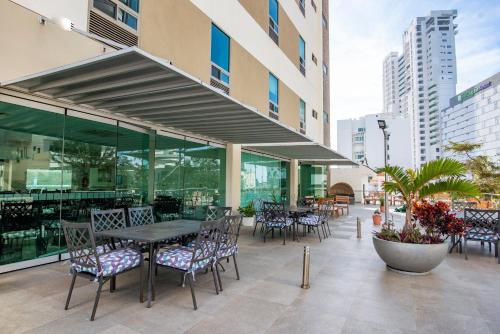 a patio with tables and chairs in a building at Hotel Ave Inn in Mazatlán
