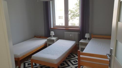 Habitación pequeña con 2 camas y ventana en GreyT, en Toruń