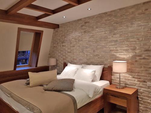 a bedroom with a brick wall and a bed at LUX apartman B432 Aparthotel Vučko Jahorina - private host in Jahorina