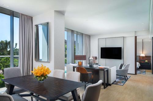 a dining room and living room with a table and chairs at Hyatt Regency Phnom Penh in Phnom Penh