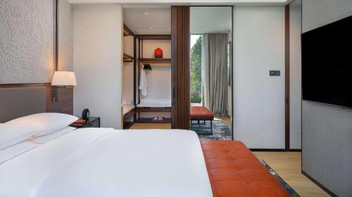a bedroom with a bed and a living room at Hyatt Regency Phnom Penh in Phnom Penh