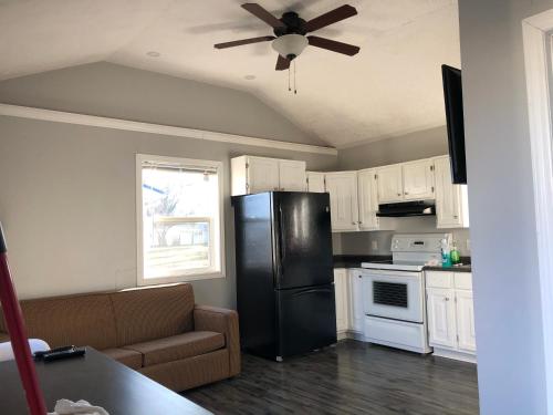 a kitchen with a black refrigerator and white cabinets at Royalty Maples Cottages and Motel in Charlottetown