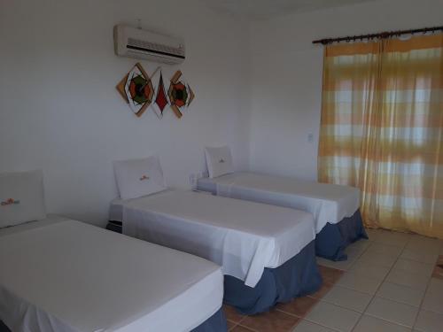 a room with two beds and a air conditioner at Hotel Pousada Summer Way in Aquiraz