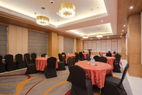 a conference room with tables and chairs and chandeliers at Ramada Encore by Wyndham Kathmandu Thamel in Kathmandu