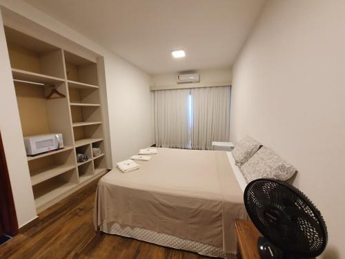 a bedroom with a bed and a couch and a microwave at Espaço Casa na Rocha in São José dos Campos
