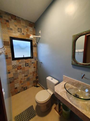 a bathroom with a toilet and a tv on the wall at Espaço Casa na Rocha in São José dos Campos