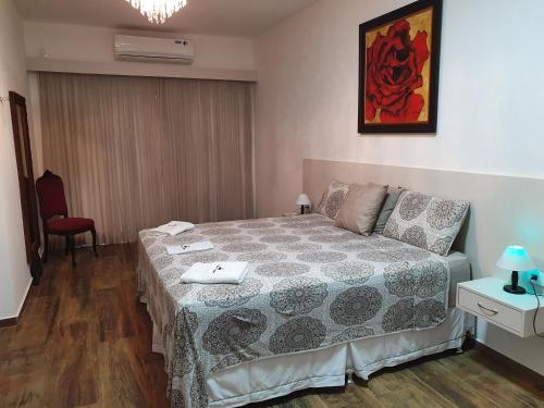 a bedroom with a bed and a red chair at Espaço Casa na Rocha in São José dos Campos