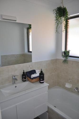 uma casa de banho com uma banheira e um lavatório em BILL'S em Coffs Harbour