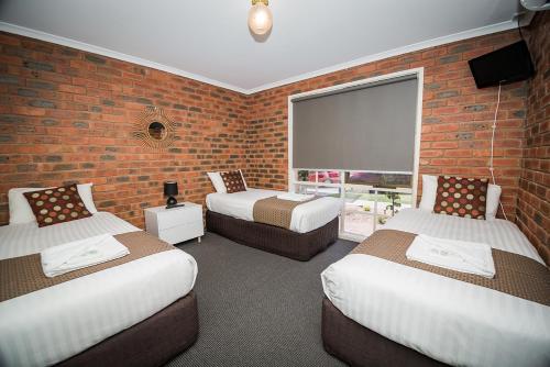 Ένα ή περισσότερα κρεβάτια σε δωμάτιο στο Australian Settlers Motor Inn