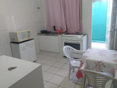 a small kitchen with a table and a microwave at Comfortable Home in Valparaíso de Goiás