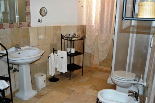 W łazience znajduje się umywalka, toaleta i prysznic. w obiekcie La Vigna Vecchia w mieście Fasano