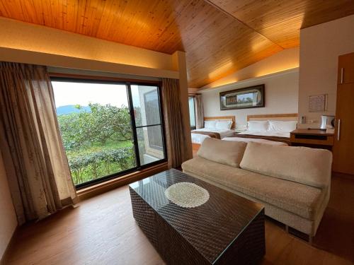 a living room with a couch and a bed and a window at 瑞穗六心居 in Ruisui