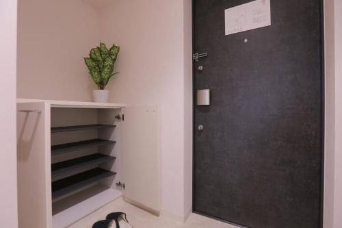 a door to a closet with a plant on it at 谷町君 星ホテル 新深江59 in Osaka