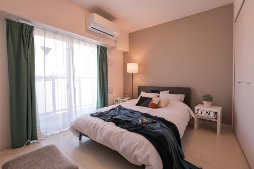 a bedroom with a bed and a large window at 谷町君 星ホテル 新深江59 in Osaka
