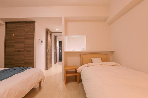 a bedroom with two beds and a closet at 谷町君 星ホテル 新深江59 in Osaka