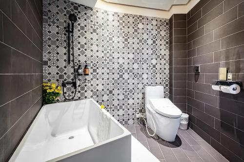 a bathroom with a white tub and a toilet at Norway Forest Travel hotel 3 Taichung in Taichung
