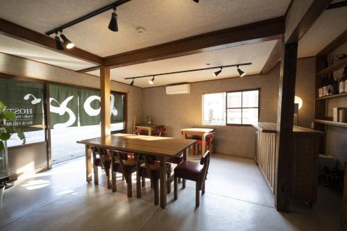 Saitosyukuba في Sonogi: غرفة طعام مع طاولة وكراسي خشبية