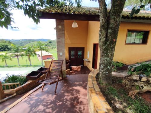 a porch of a house with a bench and a tree at Espaço Casa na Rocha in São José dos Campos