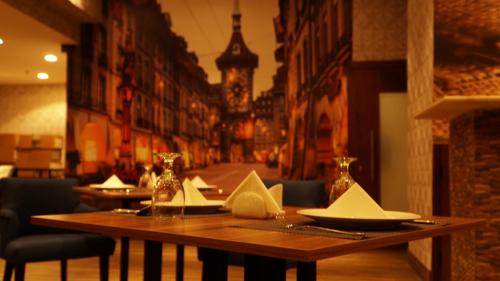 a restaurant with a wooden table with napkins on it at Eva Hotel in Jeddah