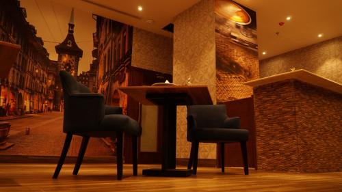 a bar with two chairs and a table in a street at Eva Hotel in Jeddah