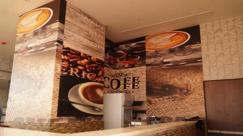 a restaurant kitchen with a coffee sign on the wall at Eva Hotel in Jeddah