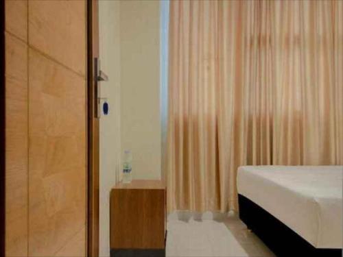 um quarto com uma cama e uma cabina de duche em vidro em Jo Homestay Cengkareng em Jakarta