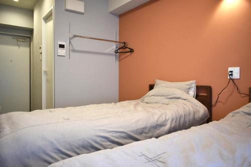 a bedroom with two beds and a mirror at GEORGE HOUSE in Tsuji in Naha