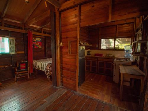 eine Küche in einer Holzhütte mit einer Spüle und einem Herd in der Unterkunft 2 bedroom cottage, 3 blocks from beach and center of San Juan in San Juan del Sur